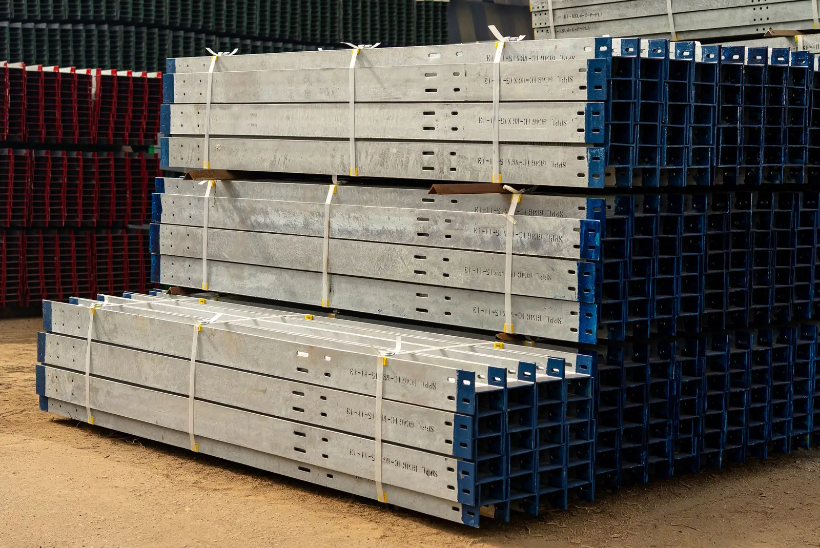Stacked construction materials and equipment staged at a jobsite laydown area