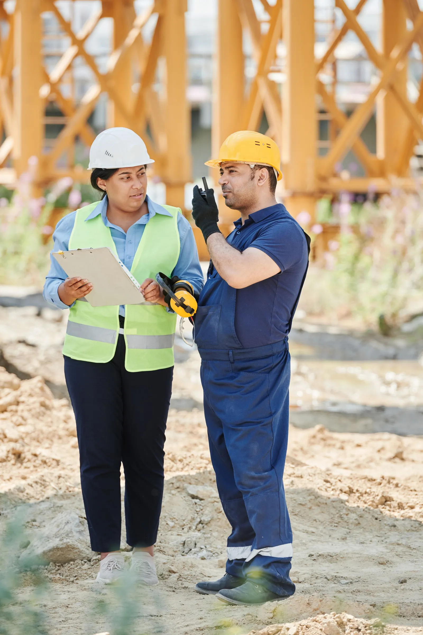 General contractor and subcontractor reviewing plans together on site